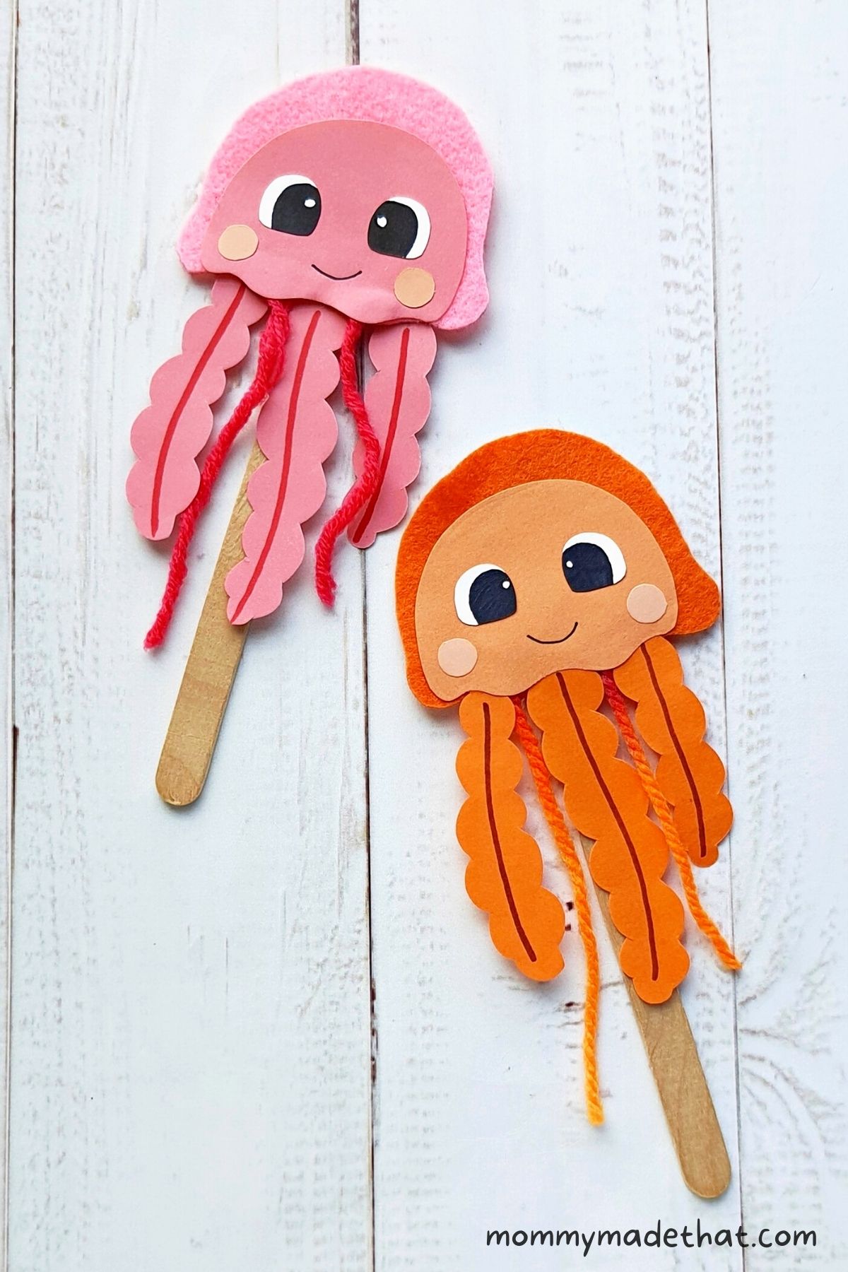 Pink and orange jellyfish puppets with yarn tentacles