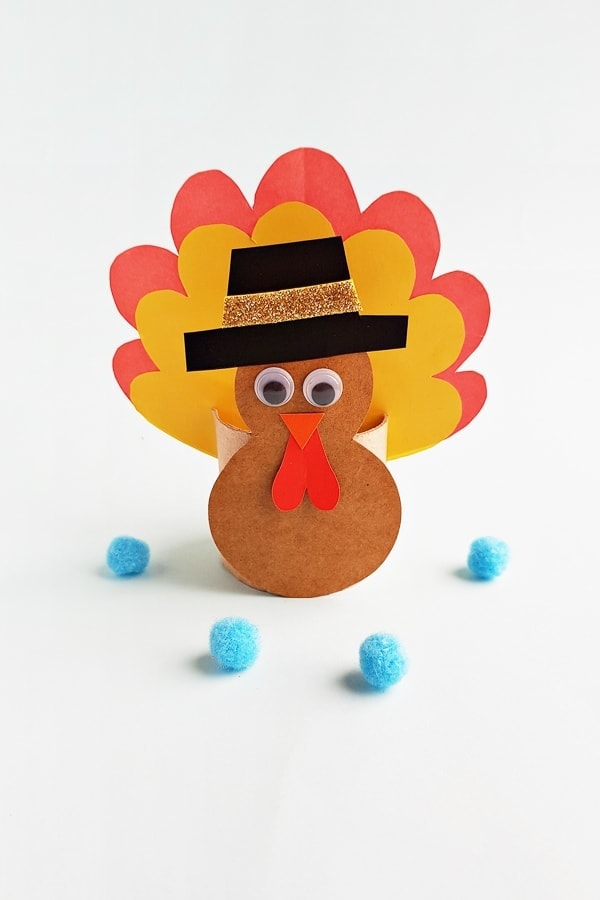 Toilet paper roll turkey with colorful feathers and a black hat